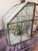 Side view showing glass panels and artificial succulents inside