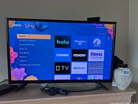 Front view of the Insignia TV screen displaying the Roku home menu interface.