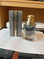 Gucci Pour Homme Eau de Toilette bottle next to its original box showing the front of the bottle and packaging.