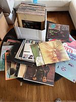 Box of vinyl records on table with some records laid out around the box