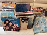 Two cardboard boxes on sofa filled with vertically stored vinyl LP sleeves