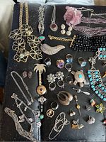 Flat lay view of assorted jewelry pieces on black background