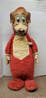 Front view of red and beige 16-inch stuffed dog cartoon character doll standing.