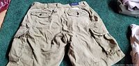 Back view of khaki men's Polo Ralph Lauren cargo shorts showing button-flap back pockets and side cargo pockets.