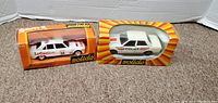 Two diecast model Peugeot cars in original Solido Gam2 packaging shown side by side on carpeted floor.