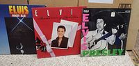 Front covers of three Elvis Presley vinyl albums - Moody Blue, Christmas album, and classic RCA Victor album.