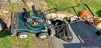 Side view of Craftsman 4.5HP yard vacuum mulcher showing engine, wheels, handle bars and attached collection bag on grass.