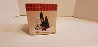 Photo shows the sealed original box of the Department 56 Kringle Place Christmas collectible figurine set. Box features image of figurines included and branding.