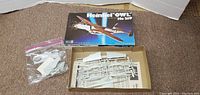 Open box with plastic sprues, loose parts in plastic bag, and instruction sheet of Heinkel Owl He 219 scale model aircraft kit