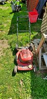 Front view of the red TORO gas-powered recycling lawn mower on grass.