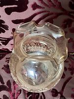 Photo of one clear glass lampshade with scalloped edge, showing geometric white printed decoration around globe.