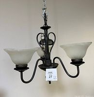Full view of the three-light chandelier with curved metal arms and frosted glass shades, showing overall design and condition.