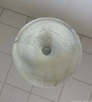 Bottom view of circular frosted glass shade with crackled texture showing wear and aging on glass edges.