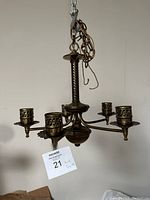 Front view of antique bronze chandelier showing the twisted central column and five arms with candle-style holders.