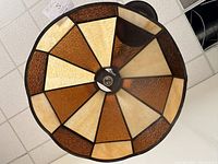 Bottom view of the stained glass ceiling light fixture showing geometric amber and cream colored glass panels.
