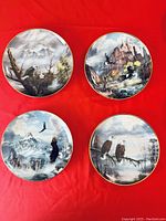 Four collectible eagle and trout scene plates arranged on red fabric, showing detailed nature artwork with eagles and mountain or water backgrounds