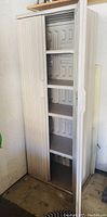 Closed Rubbermaid plastic storage cabinet showing front doors with textured panel design and vertical handles.