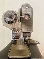 Close-up side view of the Revere Company 8 MM Projector Model 85 showing adjustment knob and lamp housing details.