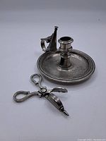 Photo showing all three items: candleholder, wick scissors, and snuffer on a white background