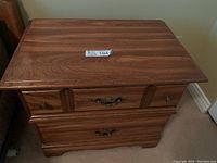 Top view showing wood grain and brass drawer handles on a solid oak bedside table.