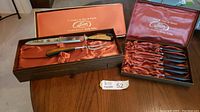 Photo showing the entire set including carving knife, fork, and separate box of six steak knives in original Cutron Canada presentation boxes lined with orange satin.