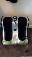 Top-down view of UComfy foot massager showing both foot compartments clearly with power cord visible.