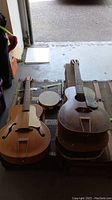 Two guitars and tambourine on trunk in garage