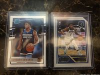 Two Anthony Edwards rookie basketball cards in protective sleeves, front view showing Minnesota Timberwolves uniforms and Panini branding.