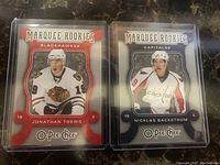 Front view of Jonathan Toews and Nicklas Backstrom NHL hockey rookie cards from O-Pee-Chee Marquee Rookies series in protective sleeves.