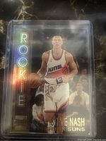 Front of Steve Nash rookie card showing holographic ROOKIE text and action image of Nash in Phoenix Suns uniform.
