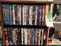 Shelf with assorted DVDs including The Simpsons boxed sets, Mad Men, Avatar, Lord of the Rings trilogy, Buffy the Vampire Slayer, Shrek, and various movies.