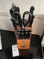 Photo of wooden knife block with 7 knives, kitchen scissors, and sharpening rod on countertop.