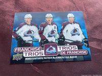 Front of the 3-D hockey card showing Colorado Avalanche players Mikko Rantanen, Nathan MacKinnon, and Cale Makar in team uniforms, with Franchise Trios branding and Upper Deck logo.