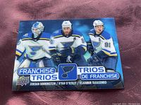 Front side of the 2020-21 Upper Deck Tim Hortons Franchise Trios card showing Jordan Binnington, Ryan O'Reilly, Vladimir Tarasenko in St. Louis Blues uniforms.