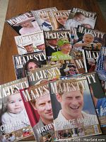 Photo showing multiple Majesty magazine issues spread out on a surface with covers featuring Prince Harry, Prince William, Princess Charlotte, Queen Elizabeth II, and others in the royal family.