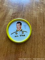 Front side of metal hockey coin showing colored portrait of Gordie Howe with All-Star title and yellow border