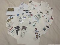 Overview photo showing multiple Canadian first day of issue envelopes with stamps and postmarks scattered about.