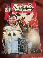 Front cover of the comic showing The Punisher in high detail with bullet casings and red background.