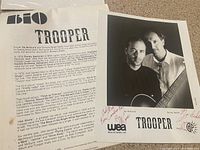 Photo of 3-page Trooper biography describing the band's history, members, and achievements on white paper.