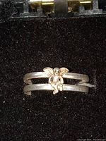 Close-up of the adjustable silver ring showing the angel motif and double band design.
