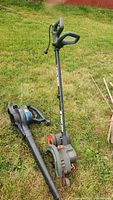 Photo of Toro blower vac Model 100-9086 and Black & Decker Edge Hog garden edger lying on grass, showing overall condition