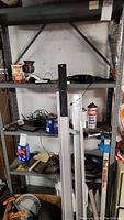 Front view of metal shelving unit filled with miscellaneous items, showing shelf structure and height.