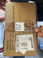 Top view of the labeled shipping box with product information including Frontgate brand and product description as artificial Christmas cheer double swag.