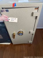 Front view of closed safe showing Amsec logo, digital keypad, gold handle and lot tag