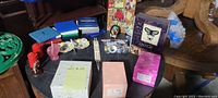 Top view photo showing a variety of small decor items including colored glassware, framed butterfly art, chopsticks, and boxed items.