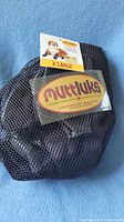 Extra large Muttluks dog booties in black mesh packaging with labels visible showing size and brand.