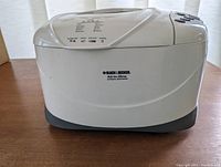 Side view of the breadmaker showing Black & Decker All-in-One branding on white body with gray base.