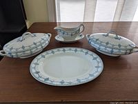 Gravy boat, two covered dishes, large platter arranged on table showing blue decorative pattern and overall condition