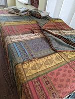Full view of the queen-sized duvet cover spread on a bed, showing multicolor patchwork pattern and tassels.
