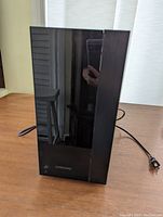 Front view of the Samsung subwoofer showing glossy black finish and Samsung branded logo near the bottom.